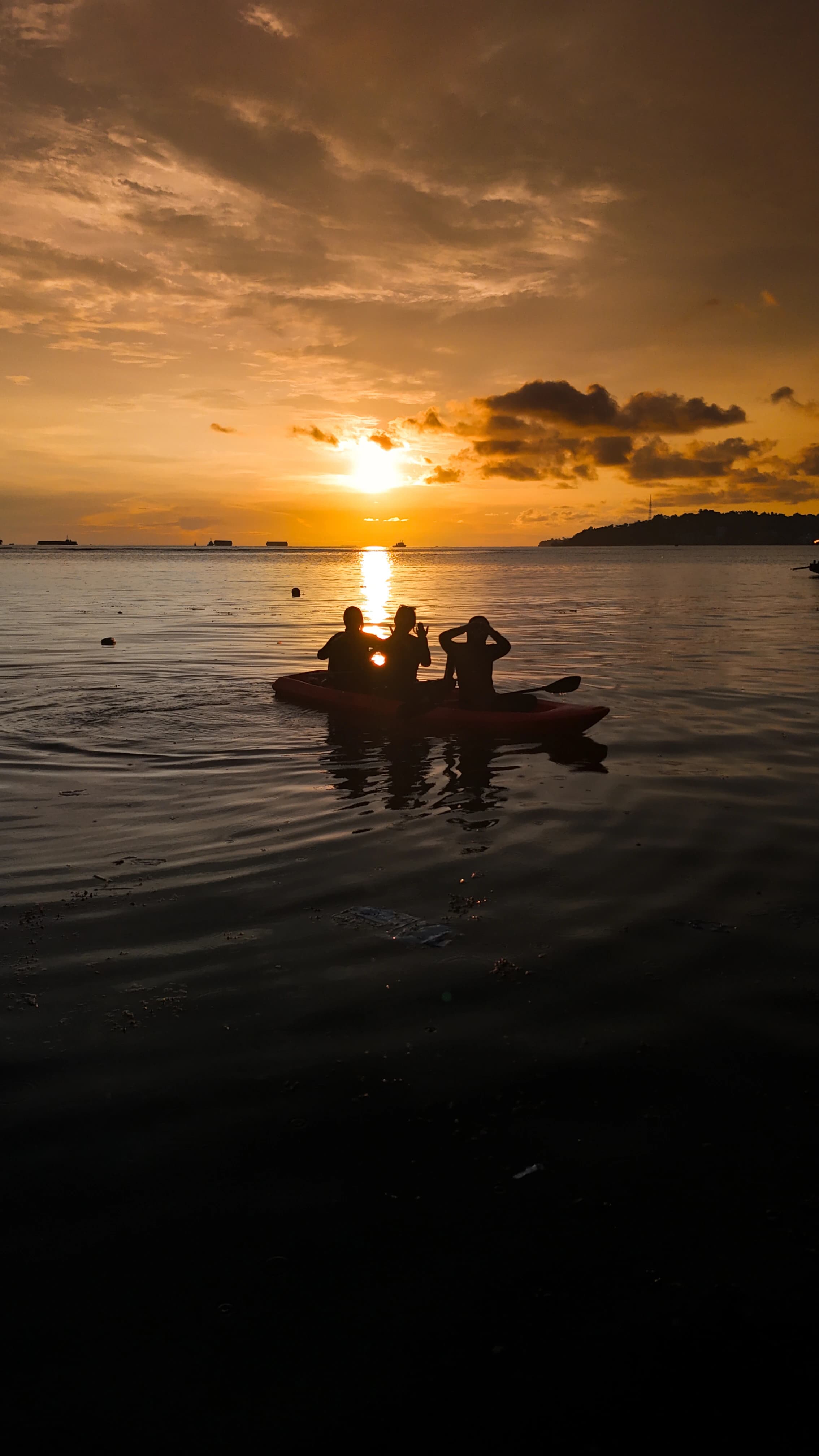 Dua kayak mendayung pulang melintasi cahaya matahari
